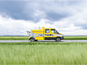 ÖAMTC roadside assistance vehicle driving through rural landscape, highlighting mobile breakdown service and in-vehicle technology